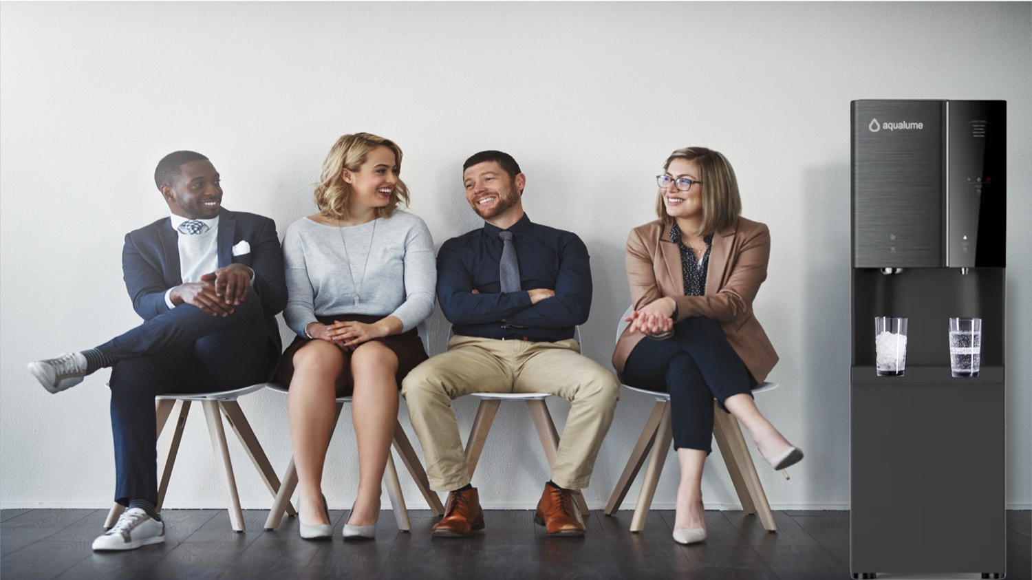 Customers relaxing in a dealership waiting area next to an Aqualume bottleless water cooler
